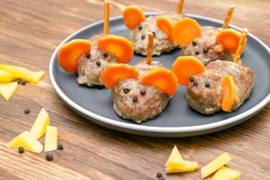 Küçük köfte faresi, havuç kulaklı köfte, tabakta peynir, çocuk partisi için yaratıcı ve eğlenceli yiyecek fikri. Ürkütücü Cadılar Bayramı tatlı ikramları için menü, yenilebilir şirin fare seçici odak.