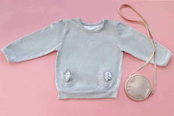 stock image Warm gray jumper,sweater,purse,little bag.Set of baby children's clothes,clothing for spring,autumn,winter on pink background.Casual fashion girls kids outfit.Flat lay,top view,mockup.