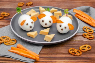 Küçük tavuk yumurtası faresi, havuç kulaklı fareler tabakta peynir, yaratıcı, eğlenceli yemekler, çocuk partisi için sağlıklı öğle yemeği kahvaltısı fikri. Ürkütücü Cadılar Bayramı tatlıları için menü, yenilebilir şirin fare..