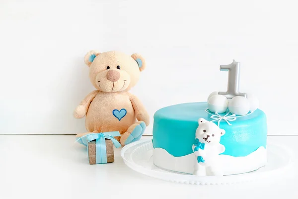 Baby blue delicious cake decorated with gift box and teddy bear for child's first birthday celebration. set with blue colors decorations for baby shower party for boy.