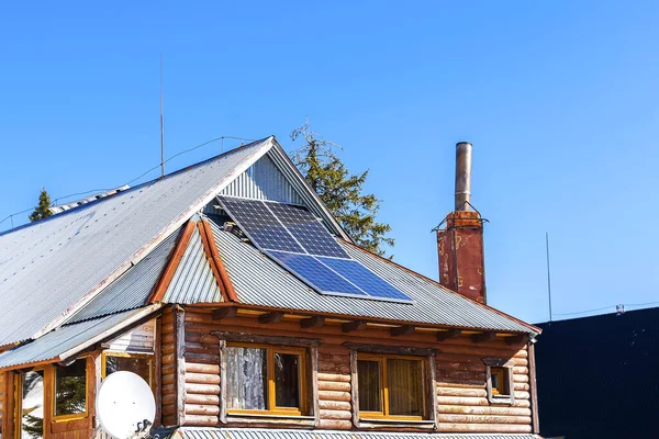 Private wooden house with blue shiny solar photovoltaic powered panels system.accumulate saving energy under sunlight. Renewable ecological eco clean electricity production.