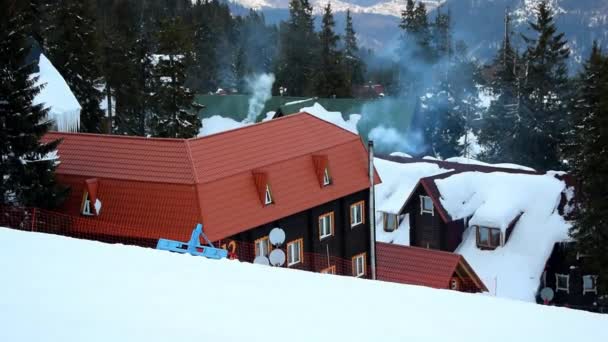 在阳光明媚 寒冷的天气里 小木村里有高山悬崖上冰雪覆盖的建筑物 冬季美丽的风景自然全景滑雪场 乌克兰喀尔巴阡山景观 — 图库视频影像