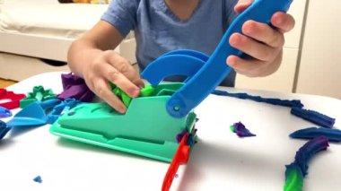 Çocuk oyun oynuyor, plastik kalıplar yapıyor. Kil kaplamalı heykeller yapıyor. Oyun hamuru. Sanat yaratıcılığı, anaokulunda zanaat.