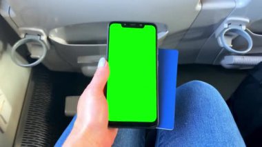 Cep telefonu yeşil ekran krom anahtar taraması, pasaport, uçak ve trenle seyahate hazırlanan bir kadın eli. Yolculuk, tatil. Yaz tatili planlama..