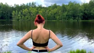 İnce bir kadının meditasyon yapması, yoga yapması, göl, nehir, su kenarında egzersiz yapması, genç bir kızın spor yapması, dinlenmesi..