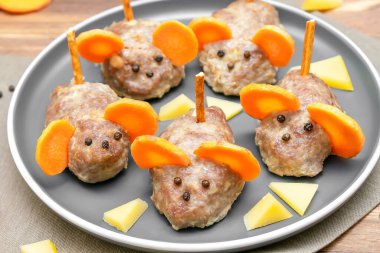 Küçük köfte faresi, havuç kulaklı köfte, tabakta peynir, çocuk partisi için yaratıcı ve eğlenceli yiyecek fikri. Ürkütücü Cadılar Bayramı tatlı ikramları için menü, yenilebilir şirin fare seçici odak.