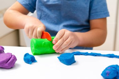 Çocuk oyun oynuyor, plastik kalıplar yapıyor. Kil kaplamalı heykeller yapıyor. Oyun hamuru. Sanat yaratıcılığı, anaokulunda zanaat..