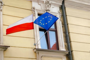 Ulusal kırmızı beyaz Polonyalı, yıldızlı mavi Avrupa Birliği bayrakları hükümet büyükelçiliği binasında asılı. Bağımsızlık veya işçi bayramı, ülkelerin dostluğu. Polonya 'nın Krakow ilçesi..