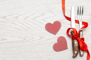 Beyaz arka planda kırmızı peçete ve çatal bıçakla servis edilen Sevgililer Günü masası. Fotokopi alanı ile romantik yemek konsepti. Üst görünüm