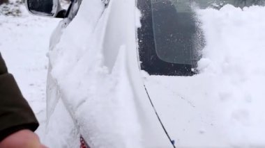 Ön camdan kar temizleyen adam. Kışın arabadan kar fırtınası üstüne kar temizleyen adam. Ön cam, pencere..