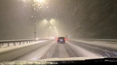 İçerideki araba penceresinden, ön camdan, kışın şiddetli kar fırtınasında yolda araba sürüşüne bak. Navigasyon, rota, araç sürüşü, ulaşım, Kiev, Ukrayna, 20.12.2021