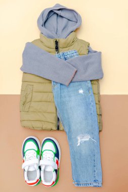 Yelek, kazak, kapüşonlu sweatshirt, kot pantolon, spor ayakkabı. Bebek kıyafetleri, kıyafetler. Moda çocuk kıyafetleri, bahar, sonbahar, sonbahar, kış için aksesuarlar..