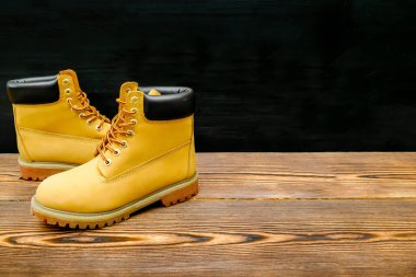 Kahverengi sıcak dağ kış izleme ayakkabıları, botlar, spor ayakkabıları, spor ayakkabıları. Ahşap arka planda günlük Timberland ayakkabı konsepti..