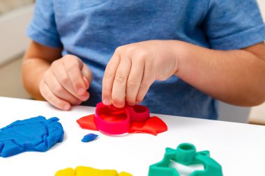 Çocuk oyun oynuyor, plastik kalıplar yapıyor. Kil kaplamalı heykeller yapıyor. Oyun hamuru. Sanat yaratıcılığı, anaokulunda zanaat..