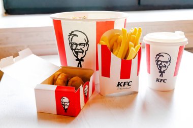 Bucket,chicken nuggets,wings,legs,Fries,coffee menu on tray in KFC restaurant.Fastfood junk food delivery,to go,takeout,take away in kraft paper eco disposable container-Kiev,Ukraine,27 December 2022