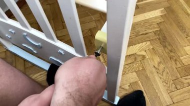 Baba beşik monte ediyor, bebek için yatak, bebek, çocuk, tornavida aletli çocuk. Marangoz işçi elleri ahşap mobilya yüklüyor.