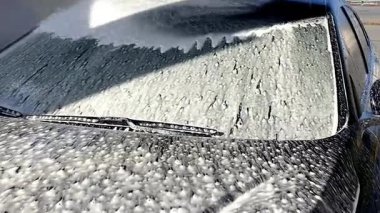 Yüksek basınçlı su jeti olan, otomatik oto yıkamada ekipman pompalı, köpüklü kimyasal deterjan kaplı bir araç.