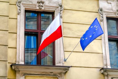 Ulusal Polonyalı, yıldızlı mavi Avrupa Birliği bayrakları hükümet elçiliğinin binasında asılı. Bağımsızlık veya işçi bayramı, ülkelerin dostluğu. Krakow, Polonya.