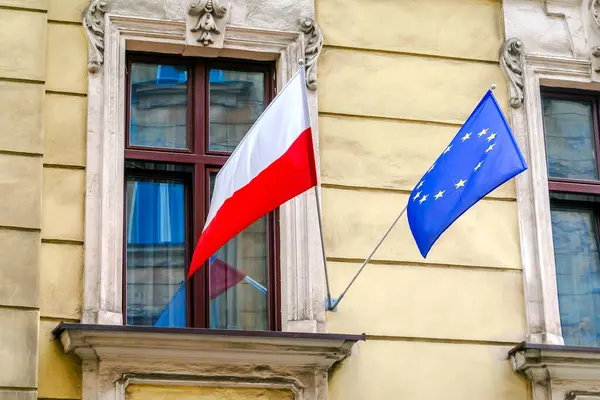 Ulusal Polonyalı, yıldızlı mavi Avrupa Birliği bayrakları hükümet elçiliğinin binasında asılı. Bağımsızlık veya işçi bayramı, ülkelerin dostluğu. Krakow, Polonya.