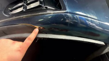 Arabasının tırmalanmasına bakan bir adam. Beklenmedik araç kazası. Yol güvenliği, araba sigortası, garaj atölyesi, otomobil servisi..