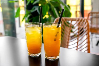 Barda, kafedeki masada bardakta taze portakal suyu kokteyli. Yaz partisi için tropikal içecek. Ferahlatıcı içecek ya da buzlu içecek..