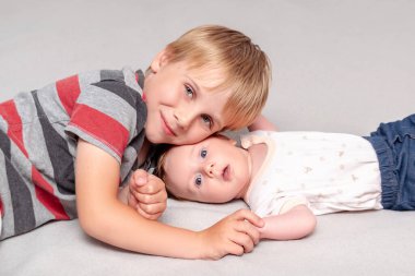 Ağabeyi sevgiyle kucaklar küçük bebek kız kardeşini. Büyük çocuk yeni kardeşiyle tanışır, birlikte yatar. Evde çocukları olan bir aile.