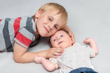 Ağabeyi sevgiyle kucaklar küçük bebek kız kardeşini. Büyük çocuk yeni kardeşiyle tanışır, birlikte yatar. Evde çocukları olan bir aile.