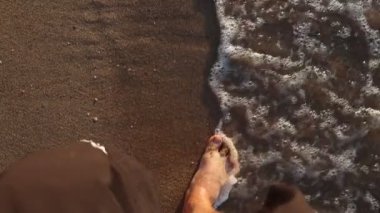 Erkekler deniz kıyısında ağır çekimde yürür.