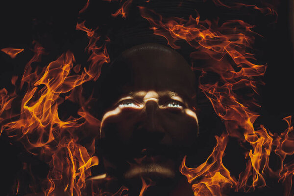 mans face in the dark on fire , cataclysms, catastrophe, war, protest