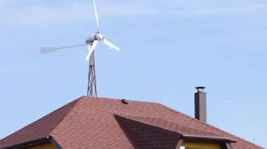 Temiz enerji iş başında. Rüzgar türbini eve yenilenebilir enerji veriyor.