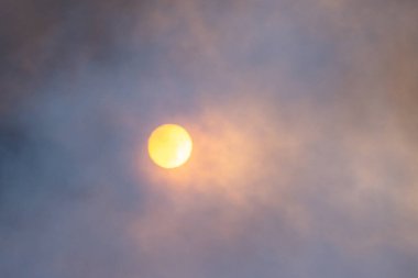 Dumanlı atmosferden sisli turuncu güneş, standart olmayan bir durum