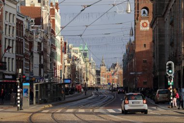 Amsterdam 'ın ana caddelerinden biri Damrak' tır, 10 Aralık 2023 'te Amsterdam, Hollanda' da saat başı hareketlilik ve hareketlilik içerisindedir.