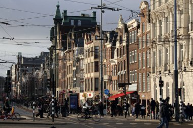 Amsterdam 'ın ana caddelerinden biri Damrak' tır, 10 Aralık 2023 'te Amsterdam, Hollanda' da saat başı hareketlilik ve hareketlilik içerisindedir.