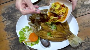 Kızarmış balık tabağına sos dök.