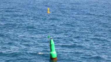 Okyanusta yüzen yeşil ve sarı şamandıralar
