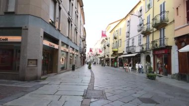 İnsanlar kaldırım taşlı bir sokakta yürüyor.