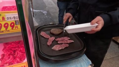 Dışarıdaki ocakta et pişiren kişi..