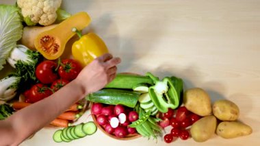 Tahta yüzeydeki taze sebzeleri elle düzenlemek.