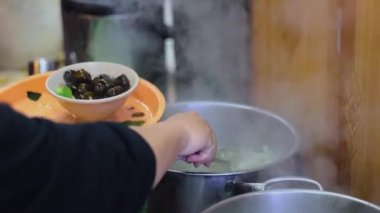 Kaynamış istiridyeleri çanaktan tabağa aktarmak