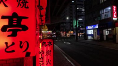 Geceleyin bir bisikletçinin geçtiği aydınlık bir cadde.