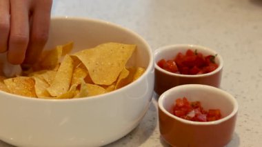 Nachos 'un salsa sosuna sırayla batırılması.