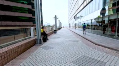 Binanın yakınındaki kaldırımda yürüyen kişi