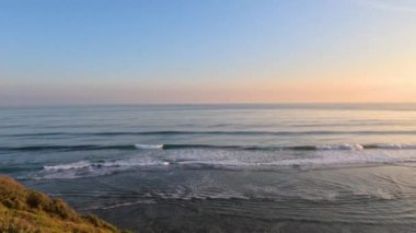 Sakin kıyı sularının üzerinde gün batımı manzarası