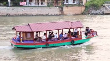 Yolcular sakin bir tekne yolculuğunun tadını çıkarıyorlar.