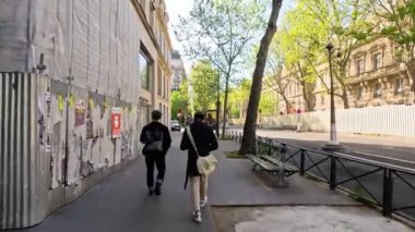 Paris caddesinde yürüyen iki kişi.