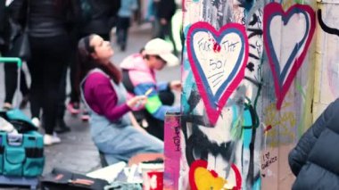 Sanatçılar Hosier Lane duvarına kalp grafitisi yapıyor