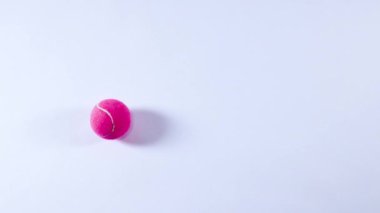 Pembe tenis topu beyaz yüzeyde zıplıyor