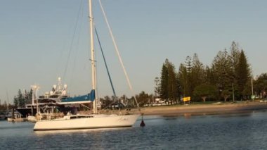 Manzaralı bir nehir boyunca yol alan yelkenli.