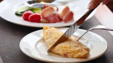 Bir tabakta kabarık bir omlet kesiyorum.