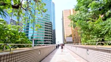 Manzaralı bir şehir yolunda yürüyen insanlar